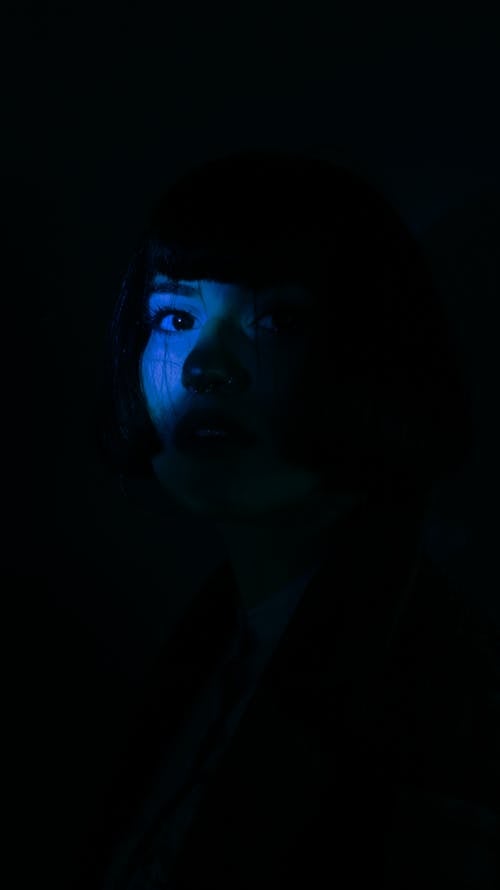 Photo of a Face of a Woman Illuminated by Blue Light 