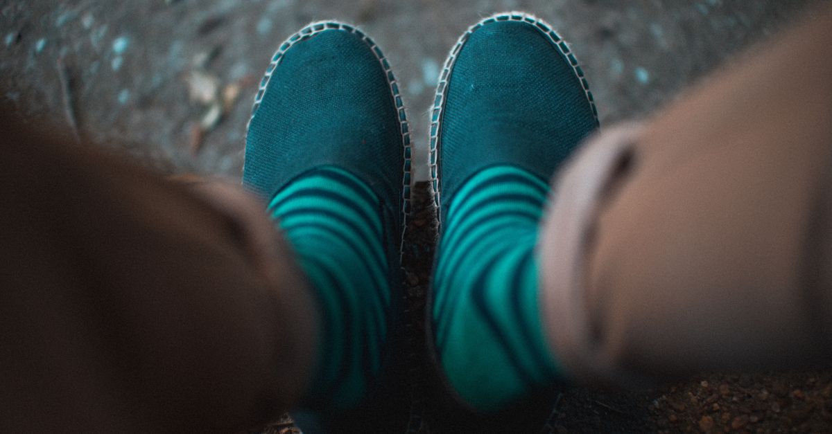 Close-up of stylish espadrilles paired with striped socks, giving a laid-back vibe.