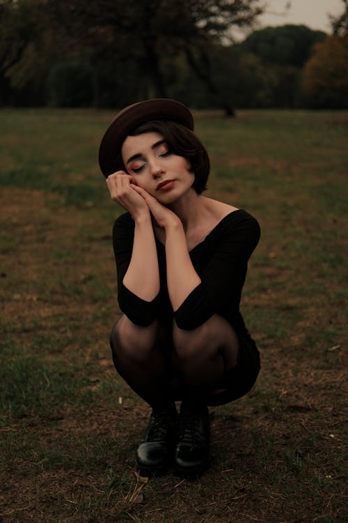 A Woman Sitting on Grass with Eyes Closed