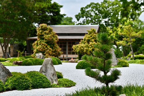 Free Peaceful Japanese garden scene with rocks, trees, and traditional house in Texas. Stock Photo