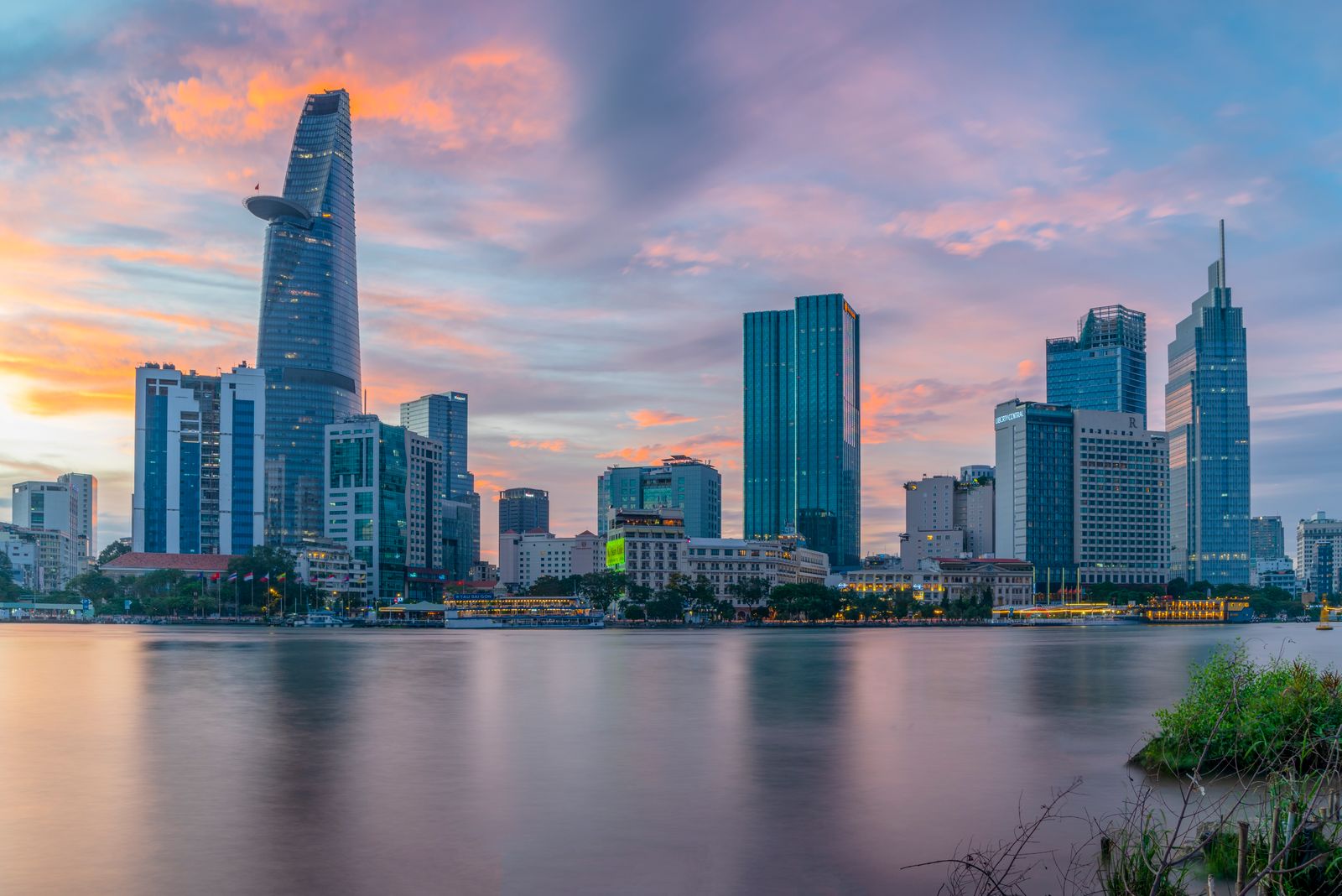 The Bitexco Financial Tower reflected in the Saigon River at sunset, Ho Chi Minh City