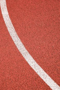 Red sports court surface with a curved white line texture, ideal for backgrounds.