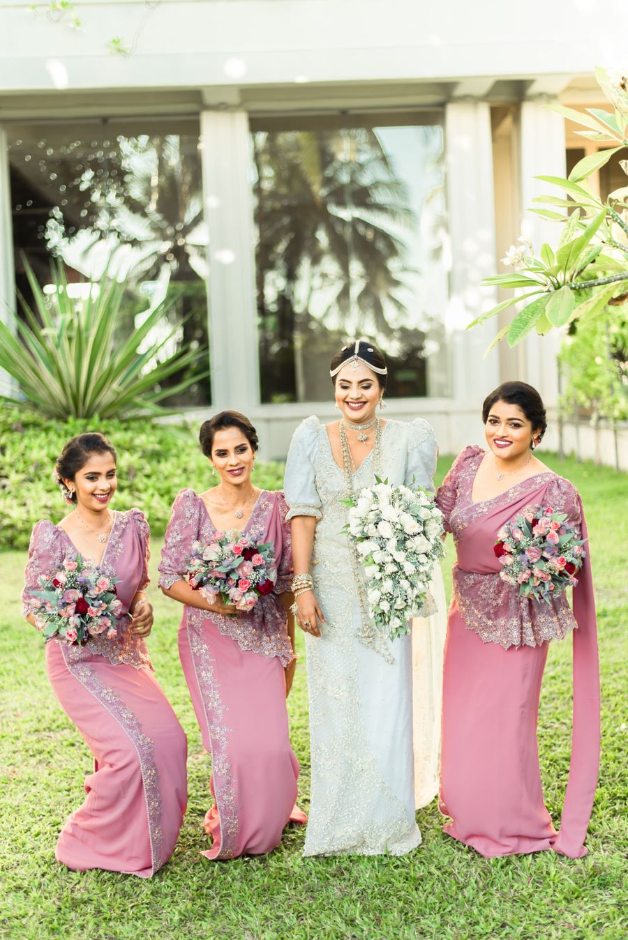 Bride with her bridesmaids in coordinated dusty-pink lace sarees