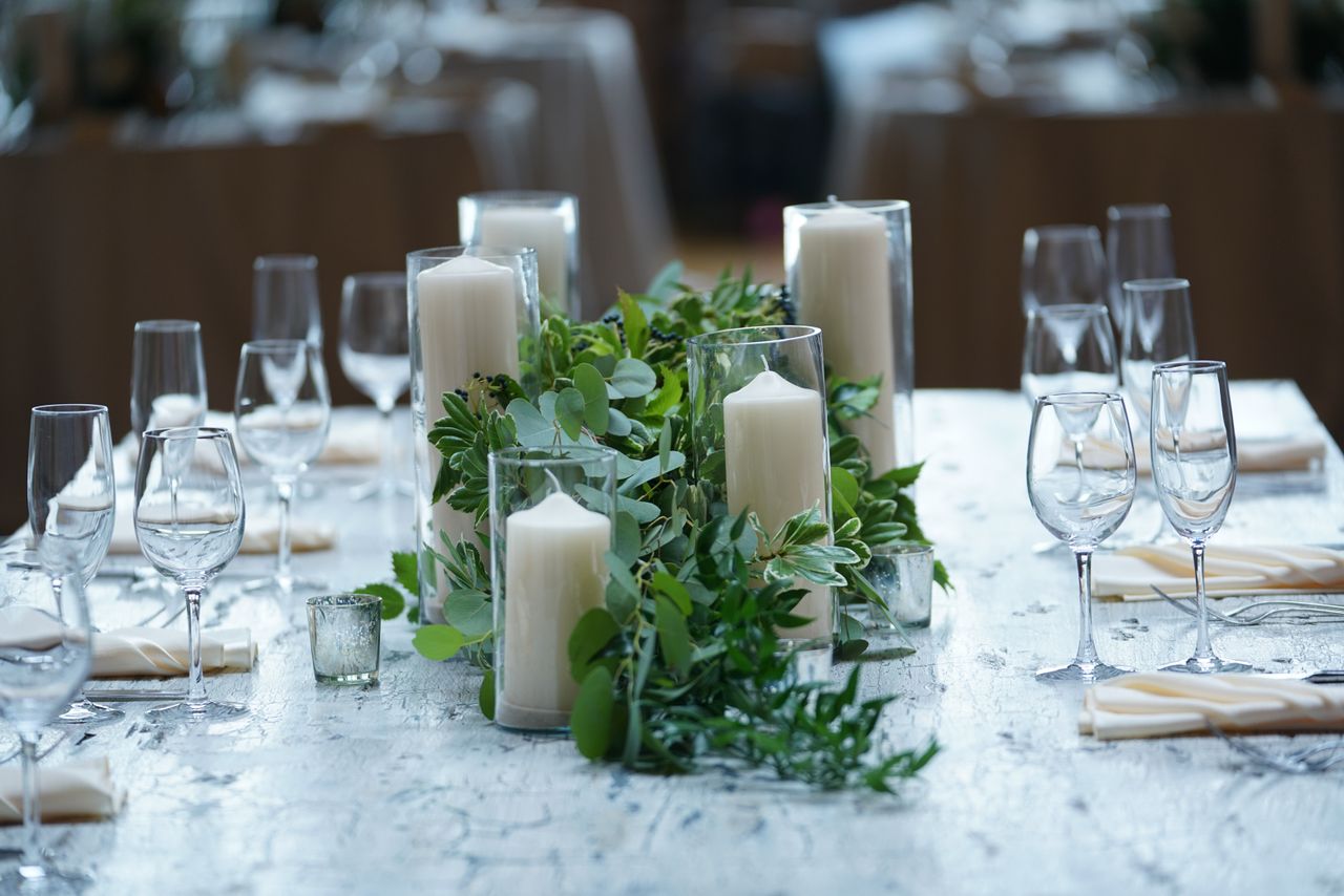 Lush greenery runner with pillar candles down the center of a table