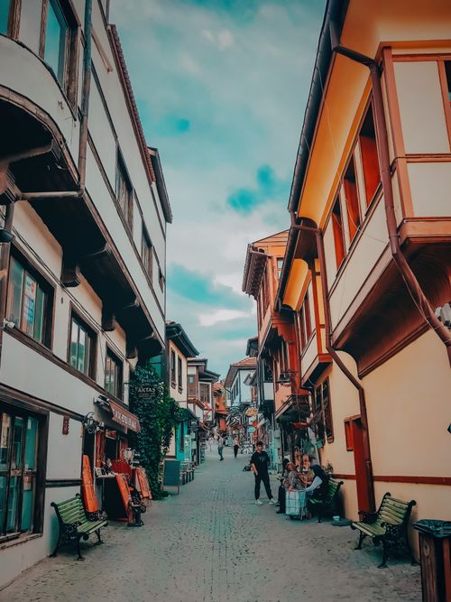 Free Discover a picturesque narrow street with historic architecture and a vibrant street life. Stock Photo