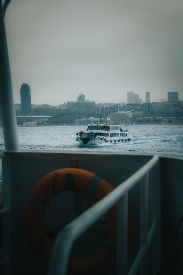 View Of Passenger Vessel Sailing On Sea With City In Background