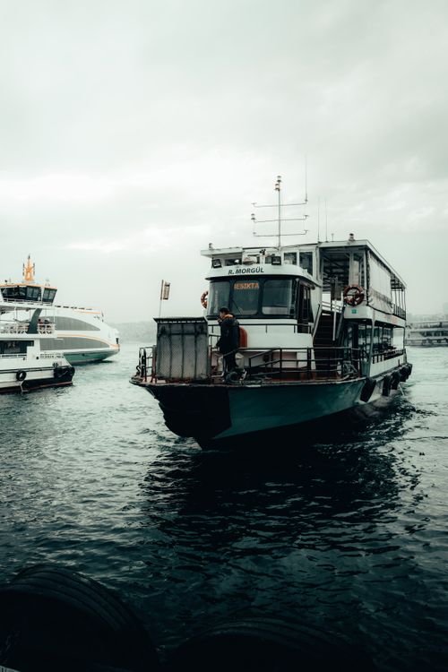 Free A ferry navigating a bustling harbor under overcast skies, capturing a crisp maritime moment. Stock Photo