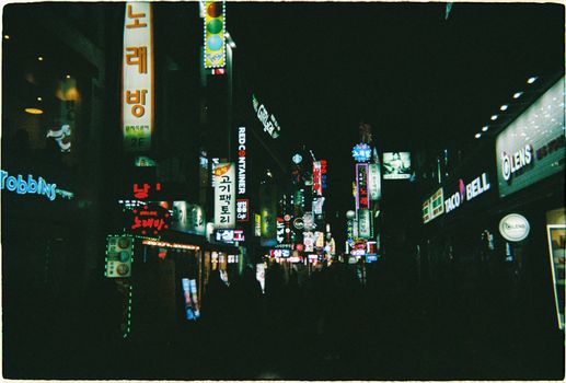 Dynamic cityscape of Seoul's nightlife, showcasing vibrant illuminated signs and a lively urban atmosphere.