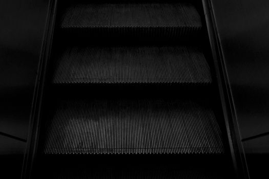 A close-up view of dark escalator steps highlighting shadow and texture.