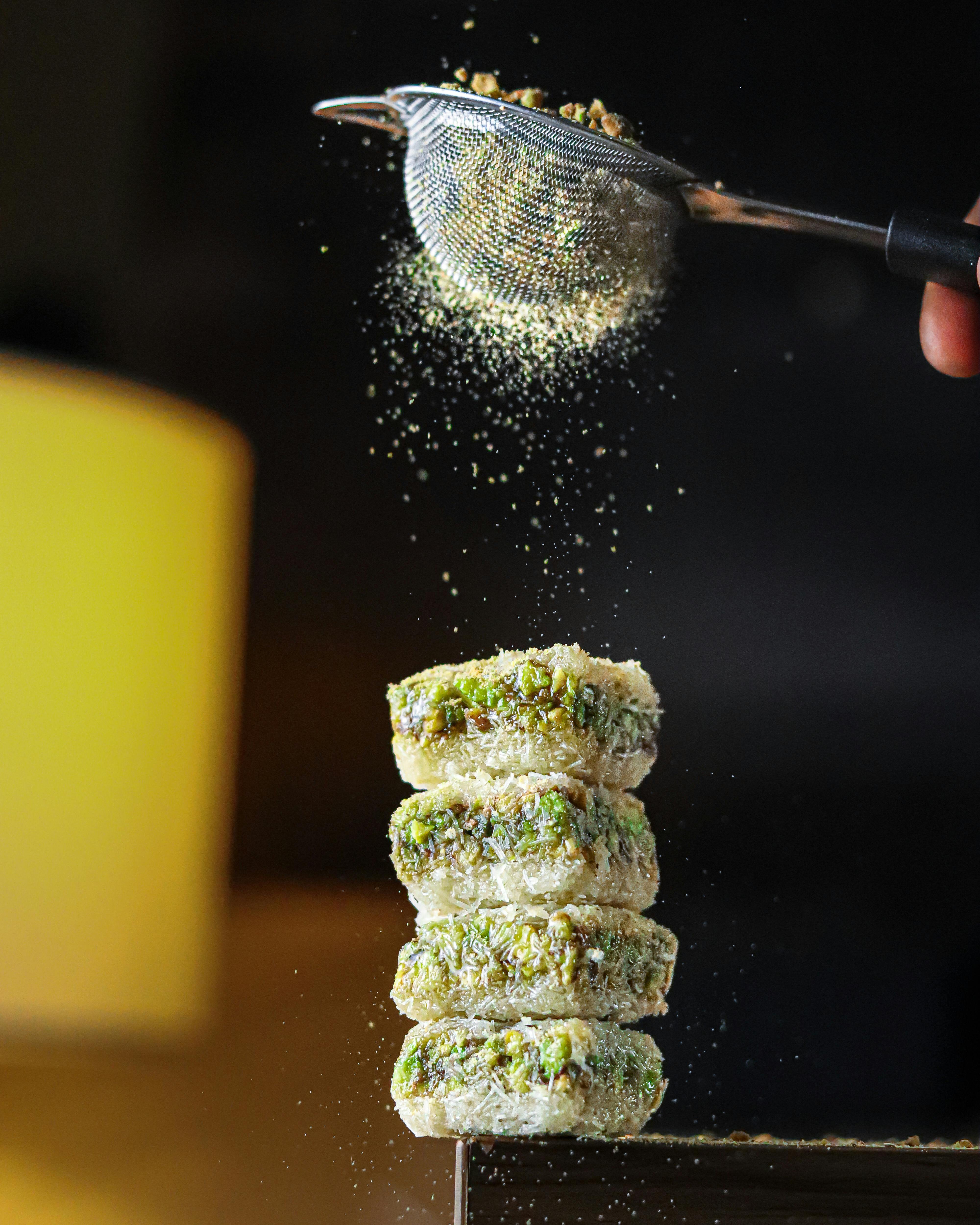 Spices Falling from a Skimmer to a Stack of Sandwiches · Free Stock Photo