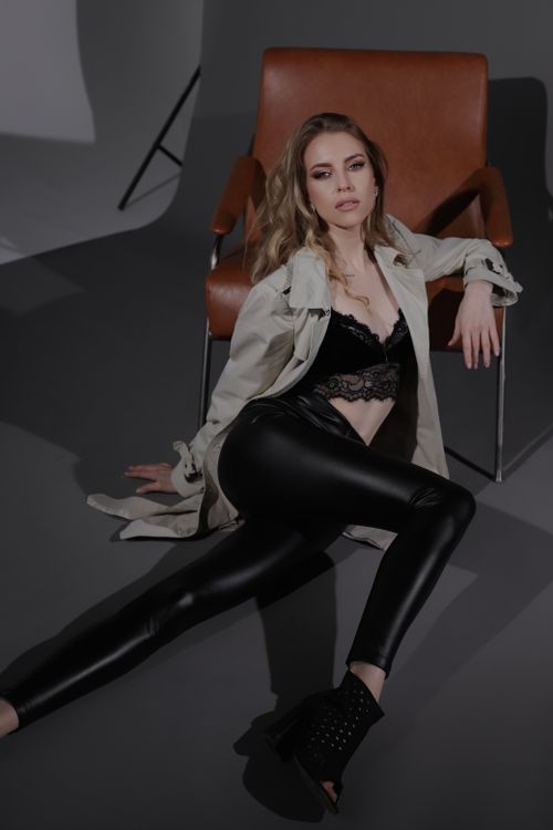 Free Stylish woman in leather pants and lace lingerie posing in a studio setting. Stock Photo