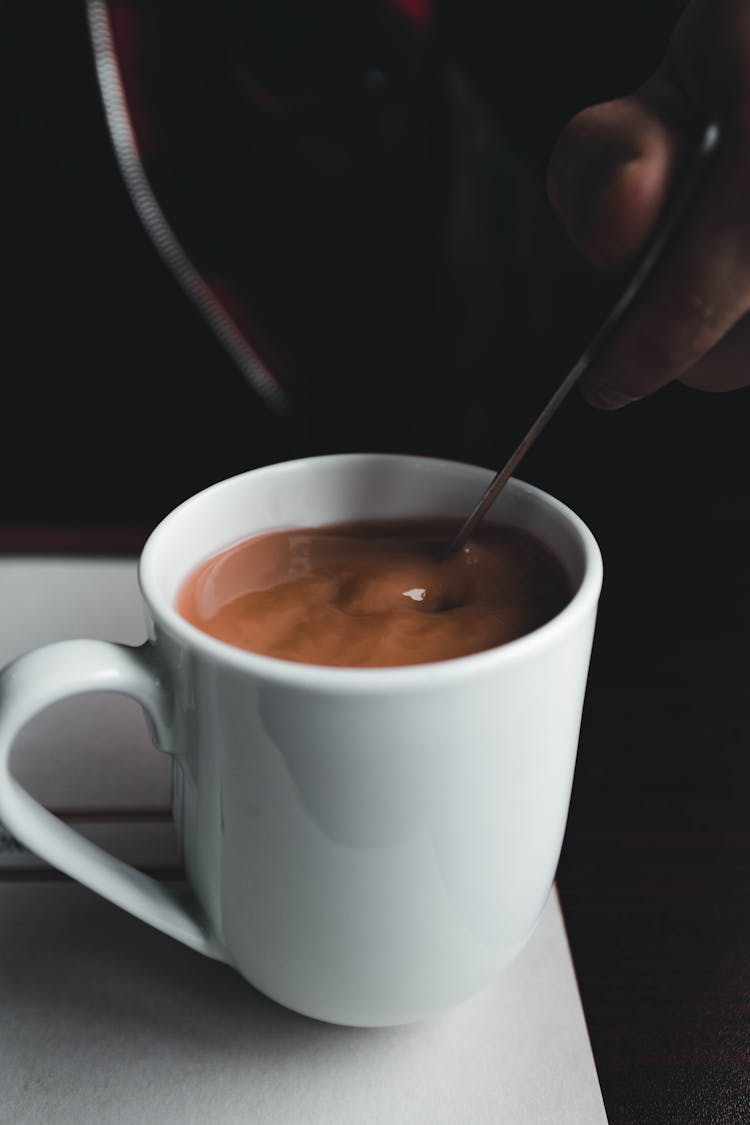 Person Stirring Cup Of Coffee 