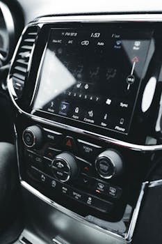 Close-up of a modern vehicle dashboard featuring various controls and digital displays.
