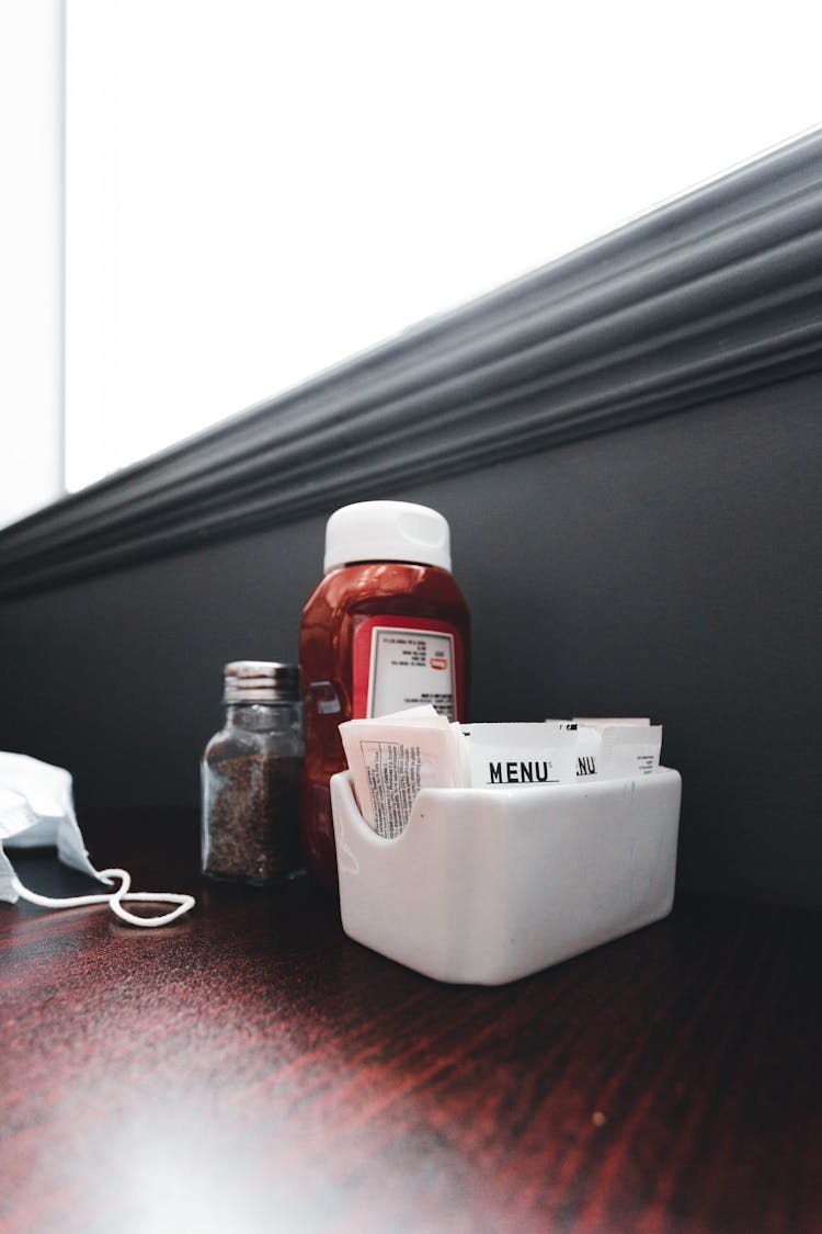 Menu In A Box, Spices And A Ketchup Bottle On A Table