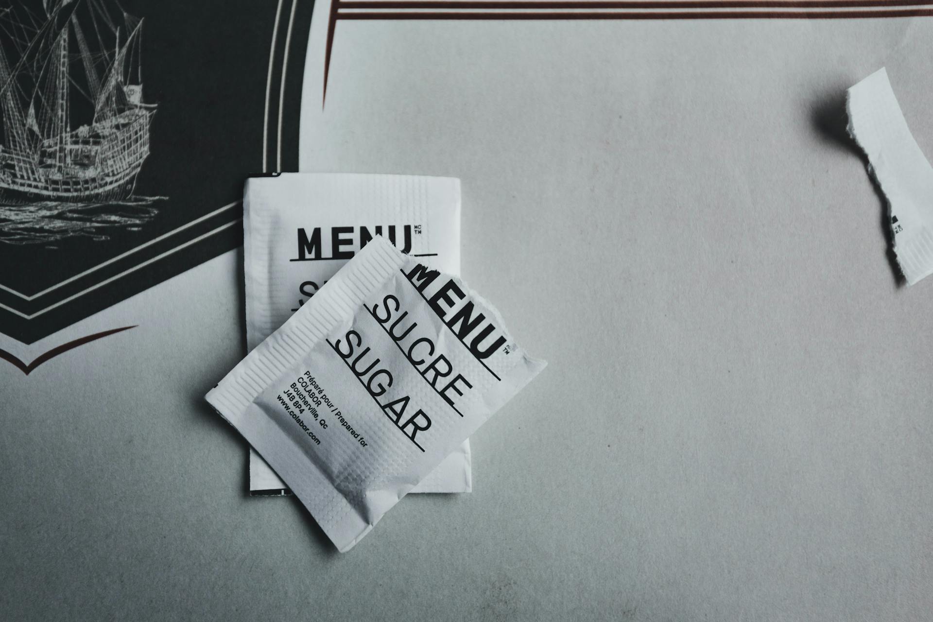 Two Paper Packages With Sugar On a Table