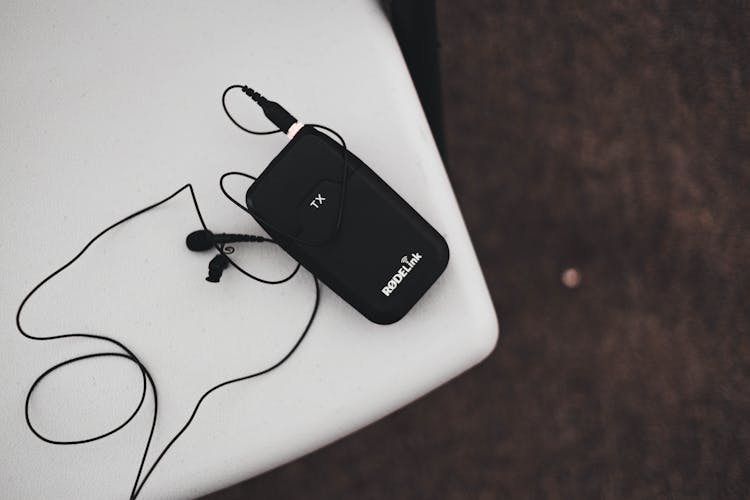 Top View Of A Portable Electronic Equipment With Headphones On A White Chair