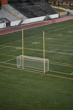 Empty sports stadium with a football goal post and bleachers viewed from above.