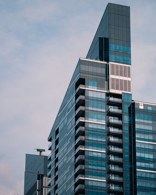 Free Contemporary glass skyscraper in Calgary against a cloudy sky, showcasing urban architecture. Stock Photo