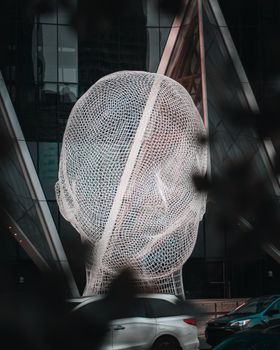 Captivating wireframe sculpture in downtown Calgary, showcasing intricate design against urban backdrop.