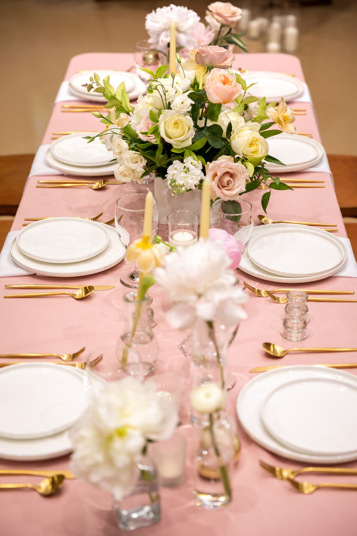 Beautiful wedding table setup with floral centerpiece and gold cutlery. Stock Photo.