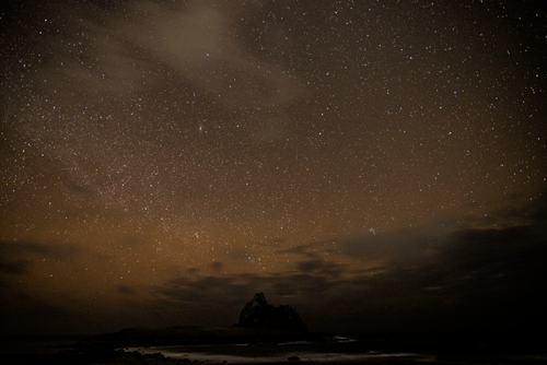 Free A captivating starry night sky over a remote mountain landscape, ideal for serene wallpaper. Stock Photo