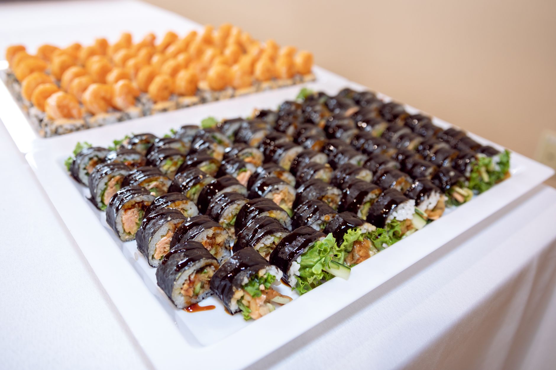 A diverse selection of sushi rolls displayed elegantly on a white tray, showcasing Japanese cuisine.