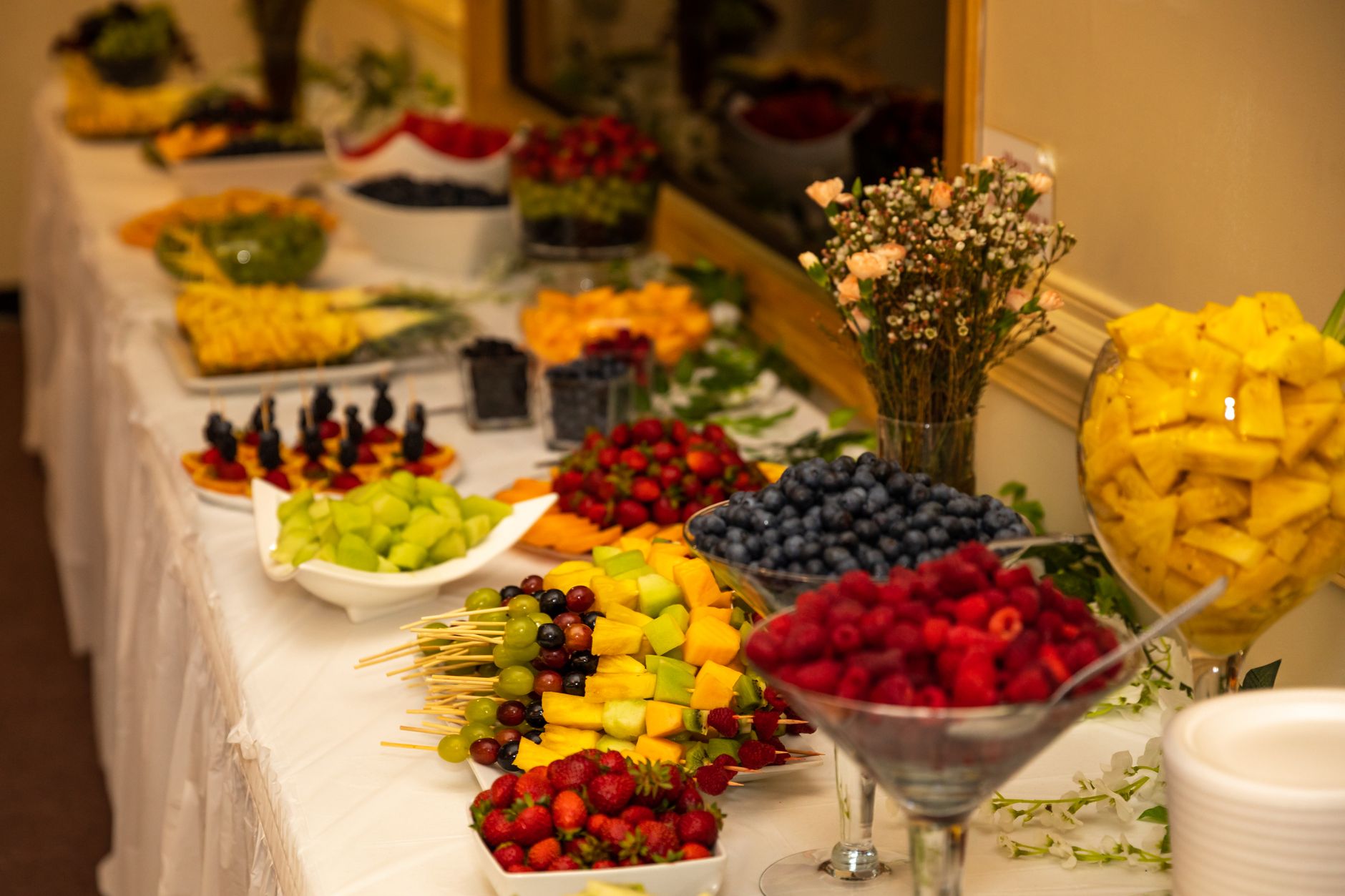 A colorful fruit buffet with a variety of fresh fruits at an indoor event.