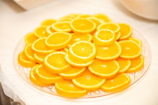 A bright and colorful display of stacked orange slices on a glass plate, perfect for healthy eating themes.