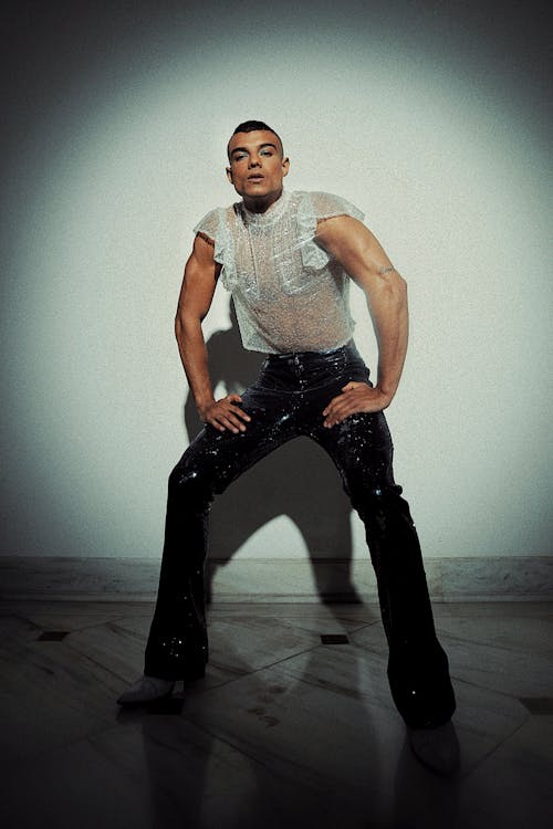 Free Man Wearing a Sheer White Top and Black Leather Pants Stock Photo