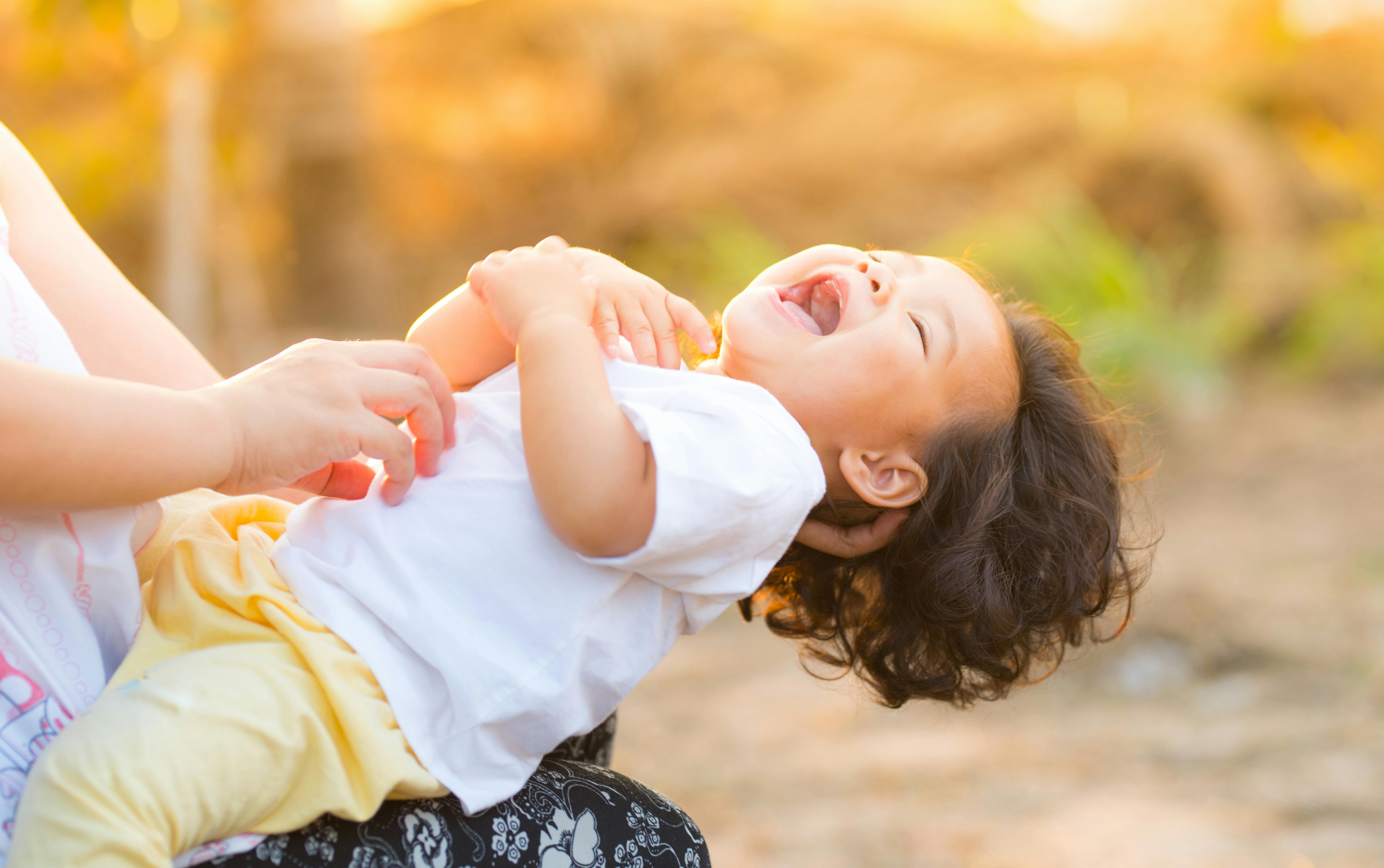 person carrying child wearing white top