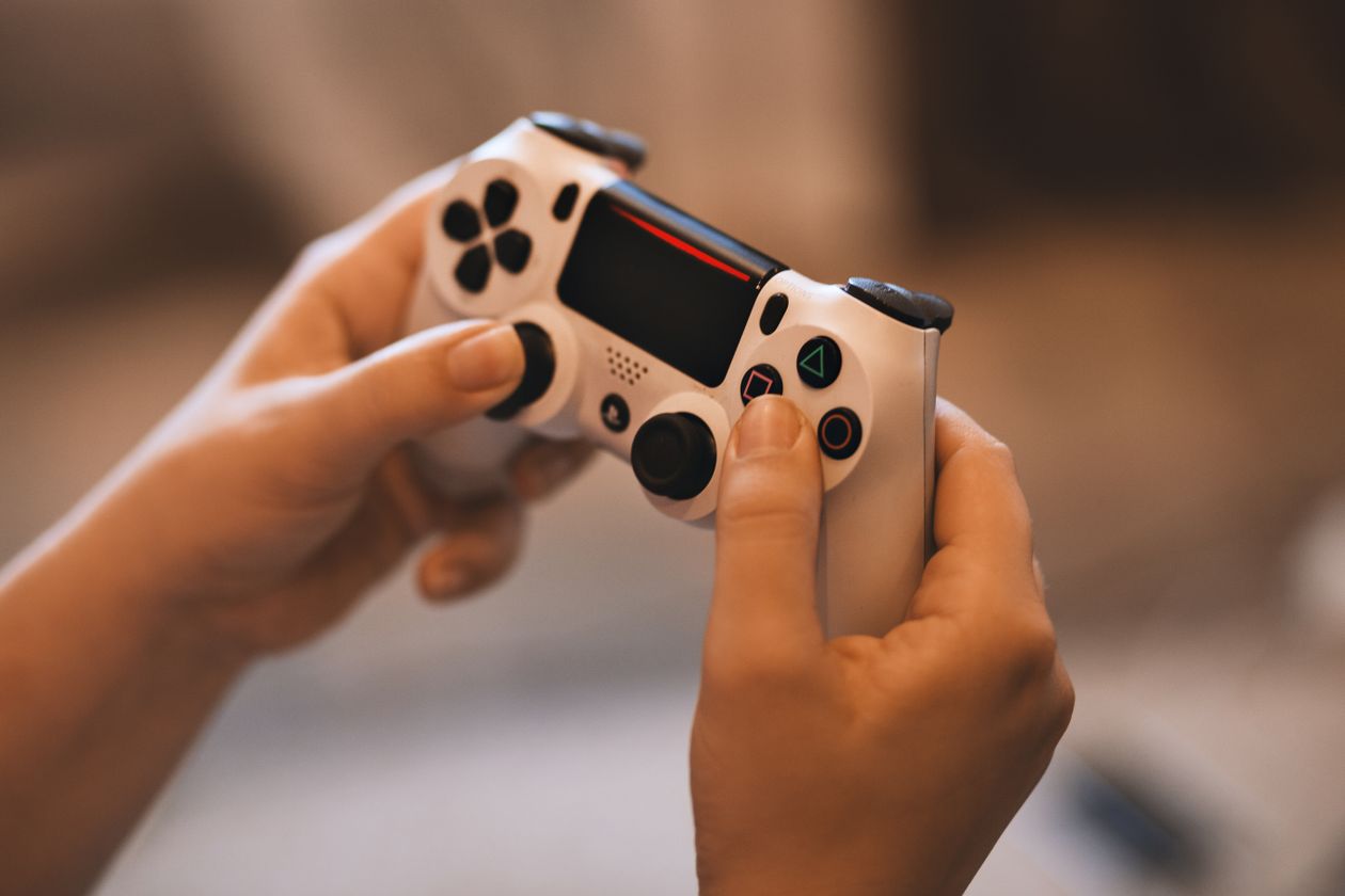 Close-up of hands holding a PS4 controller