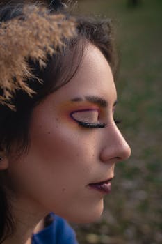 Portrait of a woman with colorful makeup against a natural background.