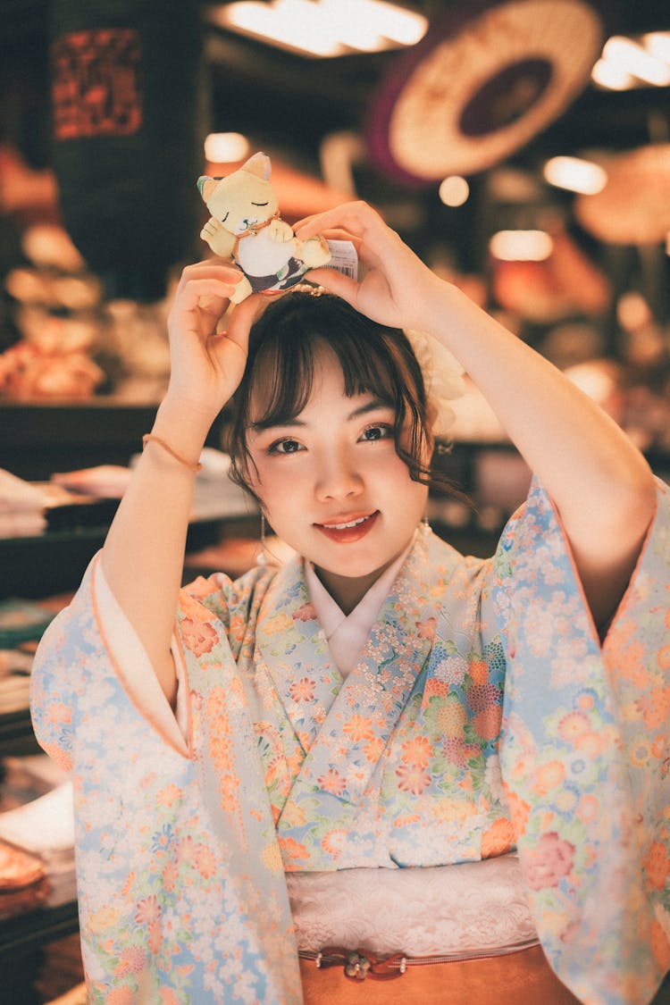 Portrait Of A Japanese Woman Holding A Toy Above Her Head 