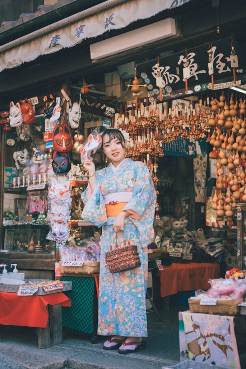 Free Woman in kimono posing outside a Japanese gift shop showcasing traditional culture. Stock Photo