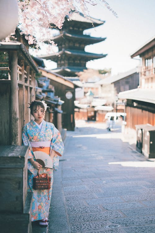 Free A Woman in Blue Kimono Standing on the Sidewalk Stock Photo