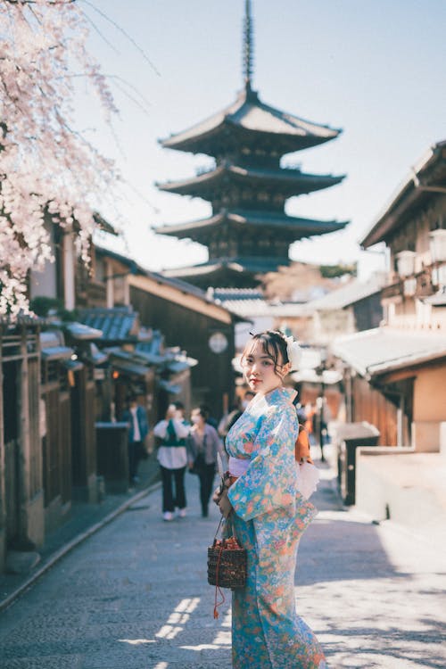 Asyalı kadın, ayakta, Budist tapınağı içeren Ücretsiz stok fotoğraf