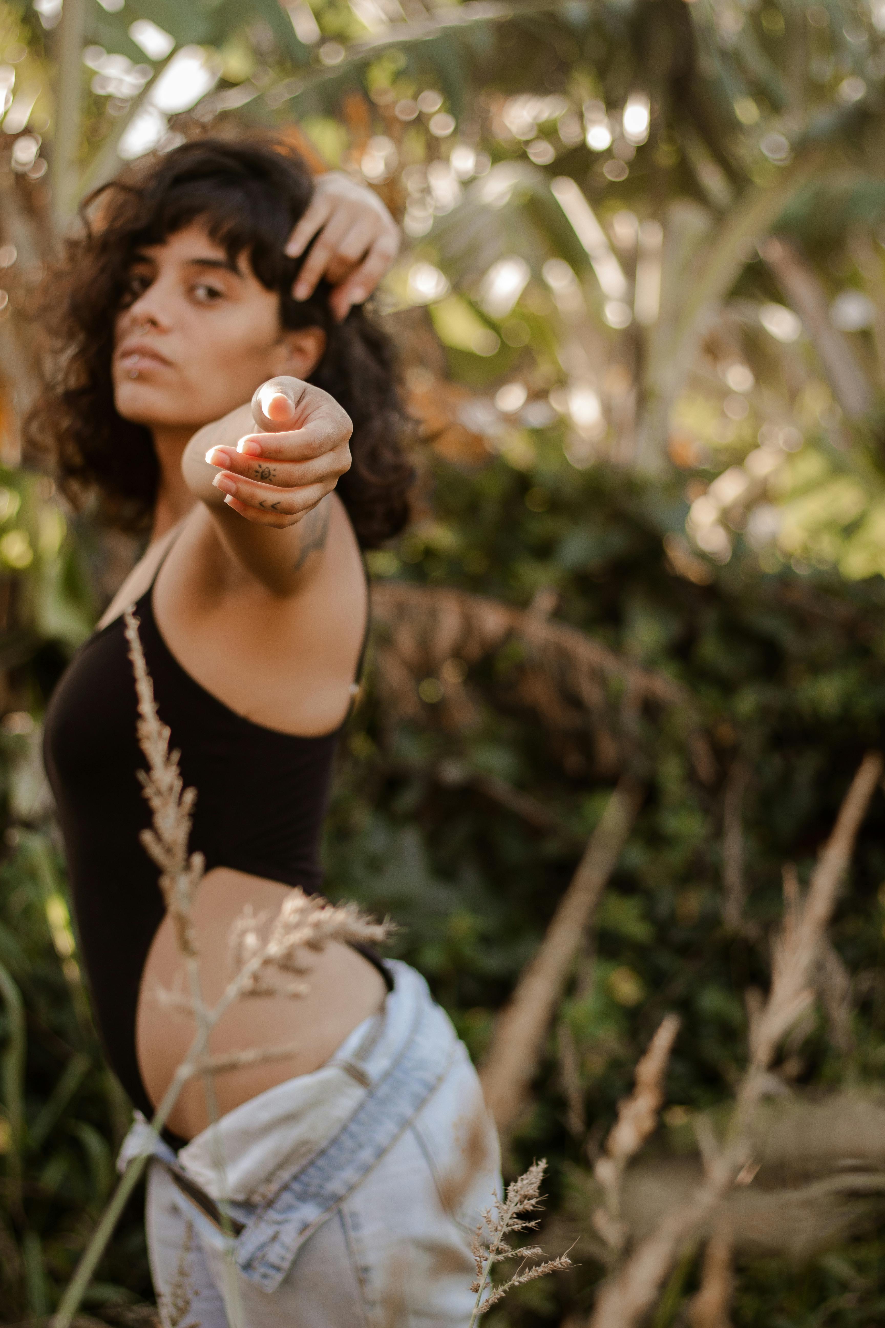 Young Woman in a Bra and Jeans Standing with her Arms Raised · Free Stock  Photo