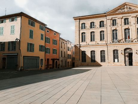 Charming European architecture in a sunlit square, showcasing colorful Provence style buildings.