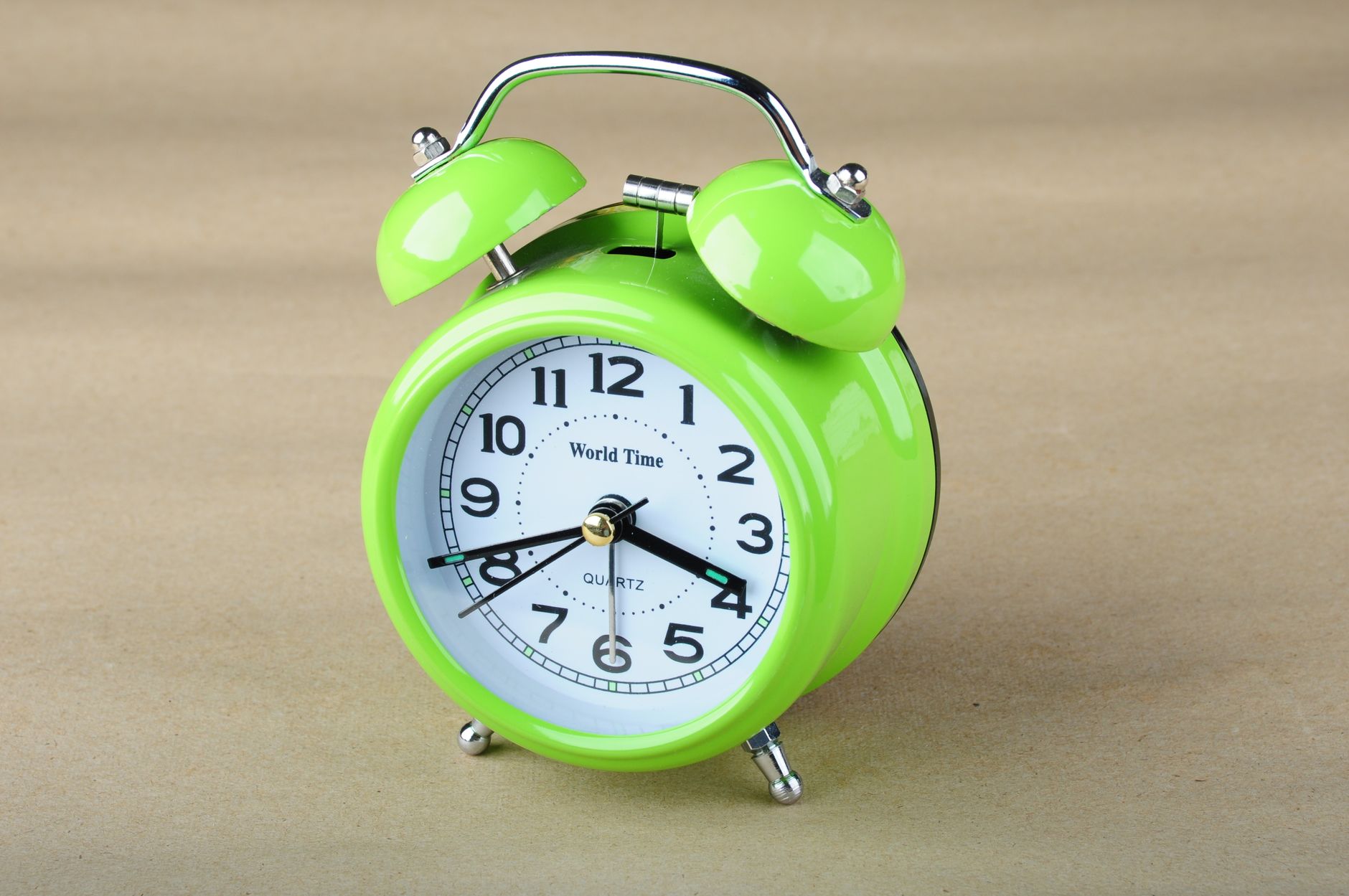 Vibrant lime green retro alarm clock showing time against a simple background.