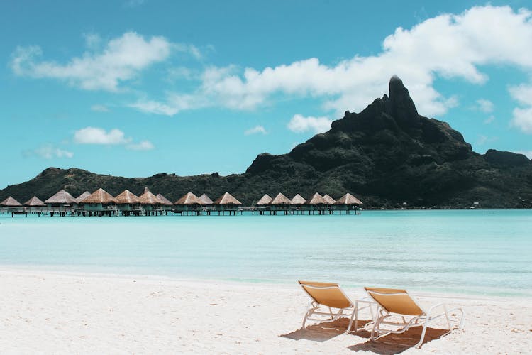 An Island With Cottages And Beach Chairs.