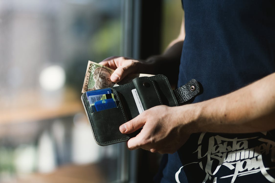 Gratis Fotografía De Persona Sosteniendo Billetera De Cuero Negro Con Dinero Foto de stock