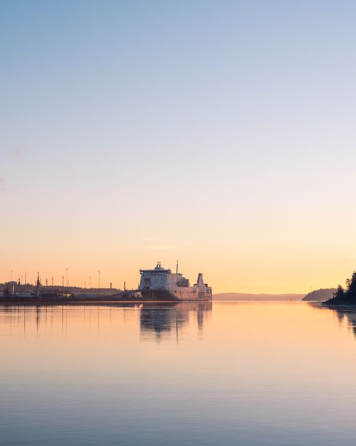 Free A tranquil scene of a cruise ship moored in Naantali, Finland, at sunset. Ideal for travel and nature themes. Stock Photo