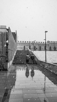 People walking up snowy stairs in Kayseri, Türkiye, captured in black and white.
