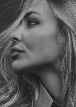 Artistic side profile portrait of a woman in monochrome, emphasizing natural beauty and elegance.