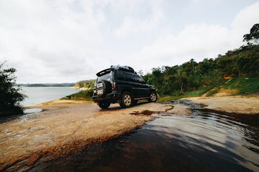 SUV parked by a scenic lakeside, ready for an off-road adventure through the wilderness.