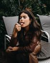 Woman Sitting on Lounger Holding a Lighter and Sticking out her Tongue