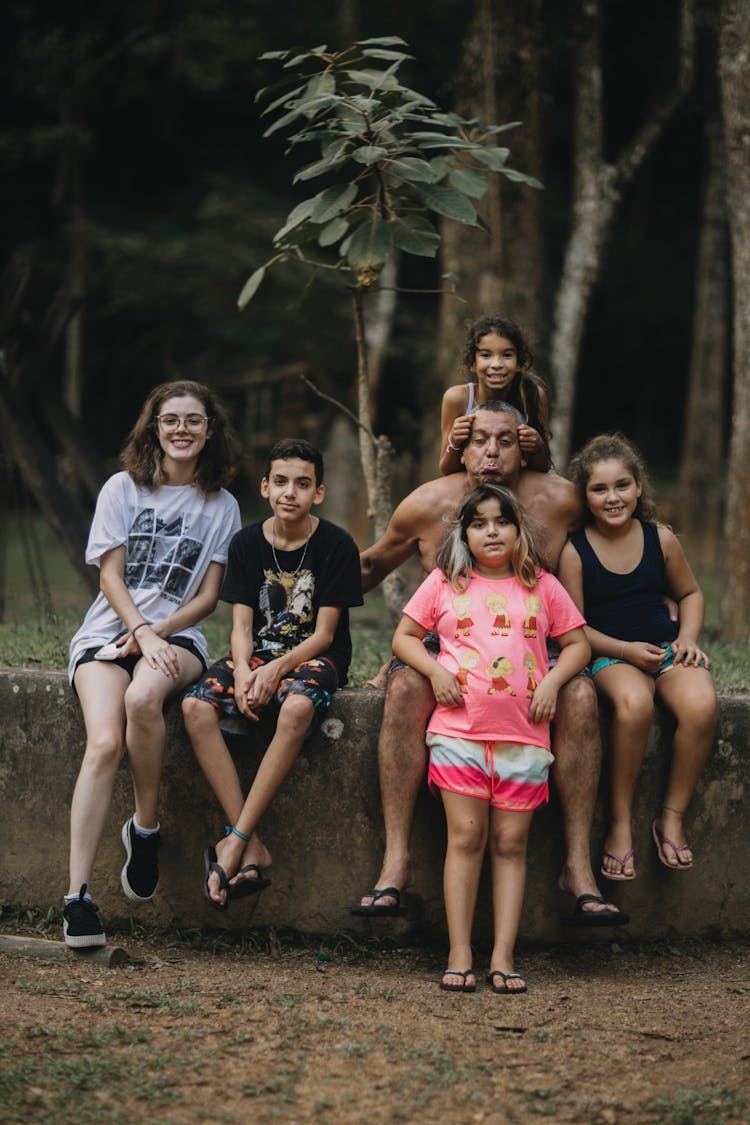 Group Of People Sitting On A Plant Box