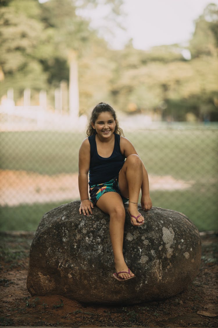 Girl Sitting On A Rock