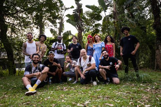 A diverse group posing happily together in a lush, outdoor setting.