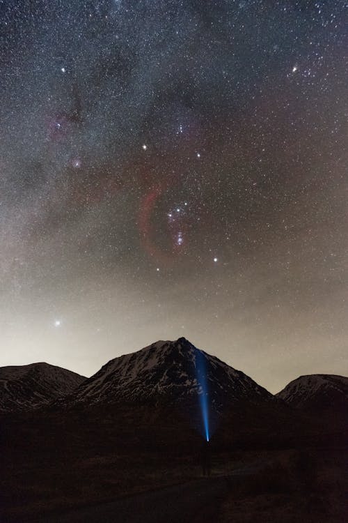 Free Glen Etive astrophotography with the Milky Way and Orion rising above a snowy mountain peak Stock Photo
